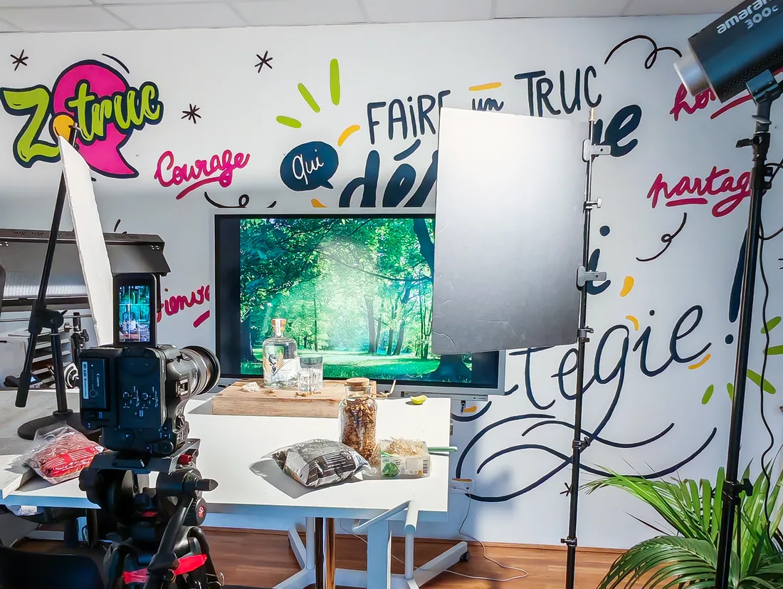 Un tournage produit au studio de l'agence : caméra sur trépied, éclairages et mur peint aux mots de la marque.