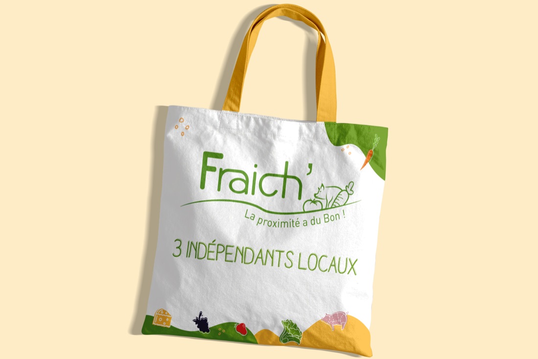 Le tote bag Fraich' : logo vert et illustration de légumes sur toile écrue, anses jaunes.