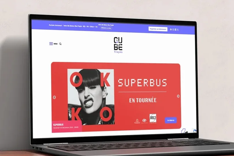 La page d’accueil du site Le Cube Troyes sur un ordinateur portable, annonçant le concert de Superbus en tournée.
