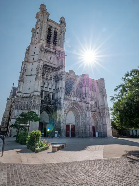 La façade de la cathédrale de Troyes, le soleil derrière la tour.