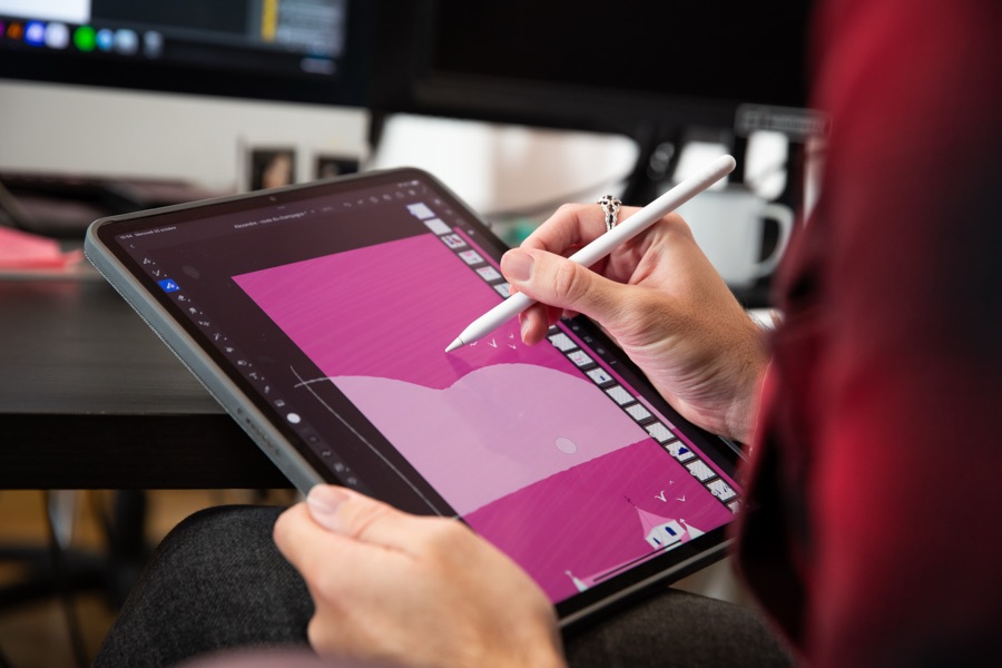 Un membre de l’équipe Zetruc dessine une illustration sur tablette graphique, au stylet.